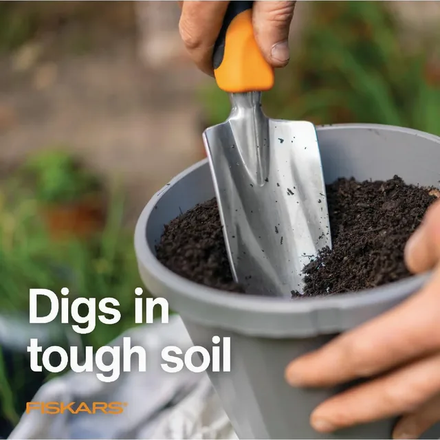 Fiskars Ergo 300S trowel digging soil in a pot, manufacturer promotional image