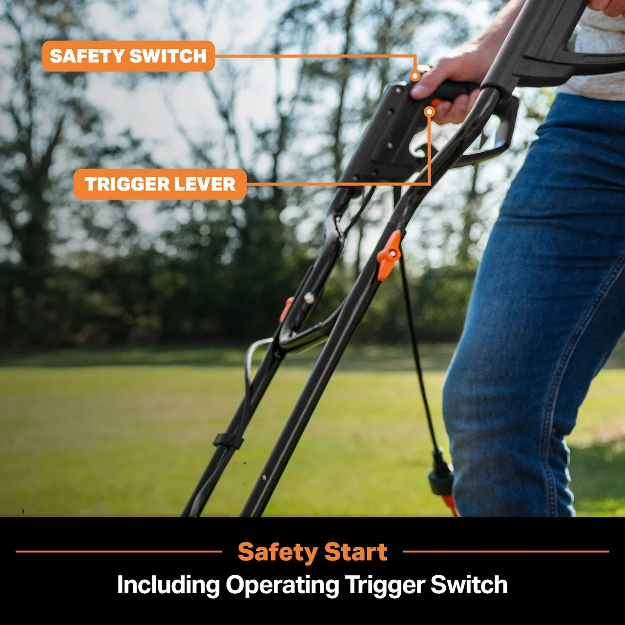 Person holding black push mower with labeled safety switch and trigger lever in a grassy yard.