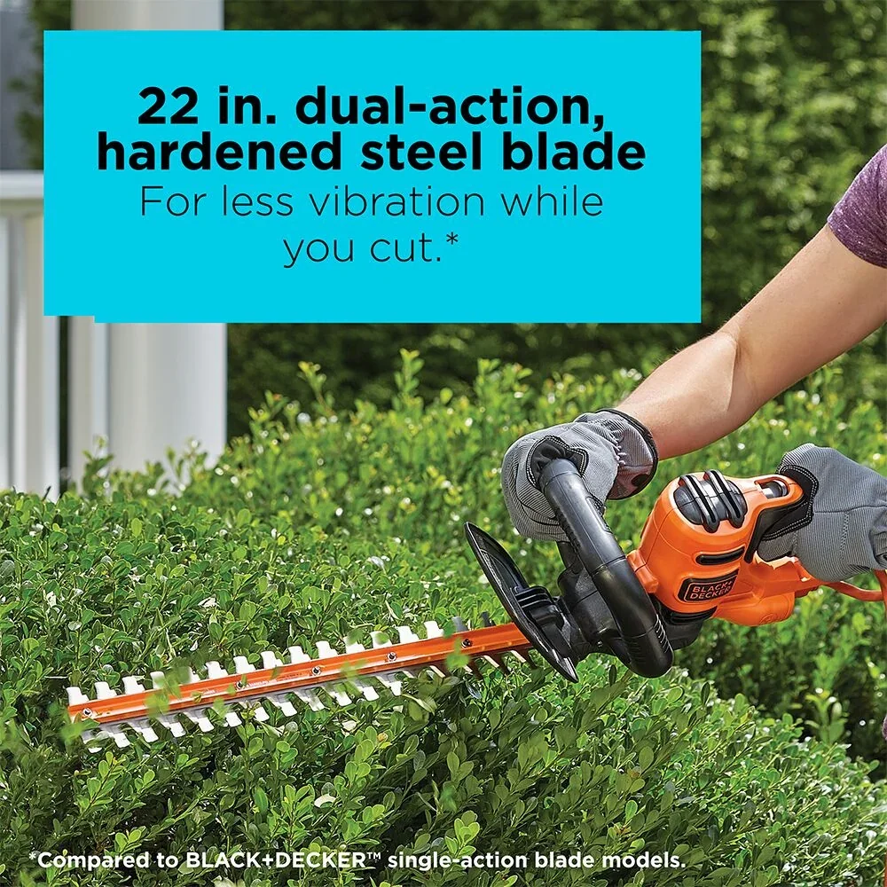 A person cuts hedges with the BLACK+DECKER 22-in. Hedge Trimmer. 22-in. dual-action hardened steel blade for less vibration while you cut.