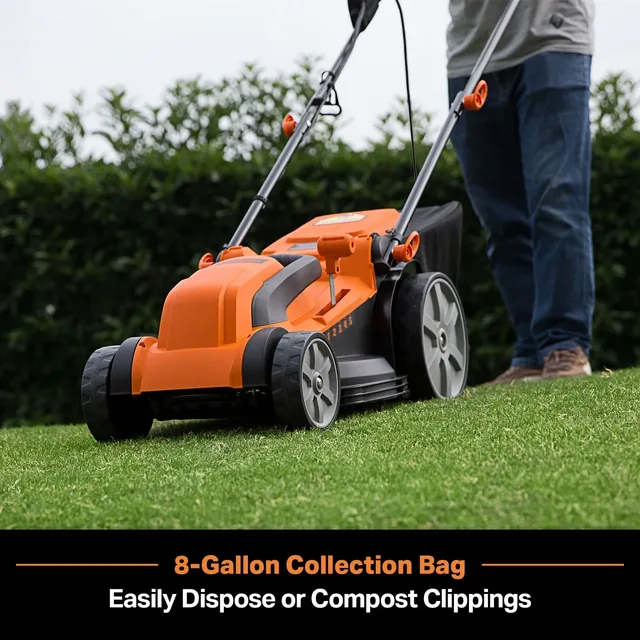 Orange electric lawn mower with 8-gallon collection bag being used on grass with hedge in background