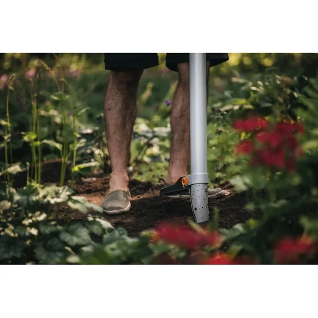 Fiskars Xact bulb planter tube and foot platform positioned in garden soil