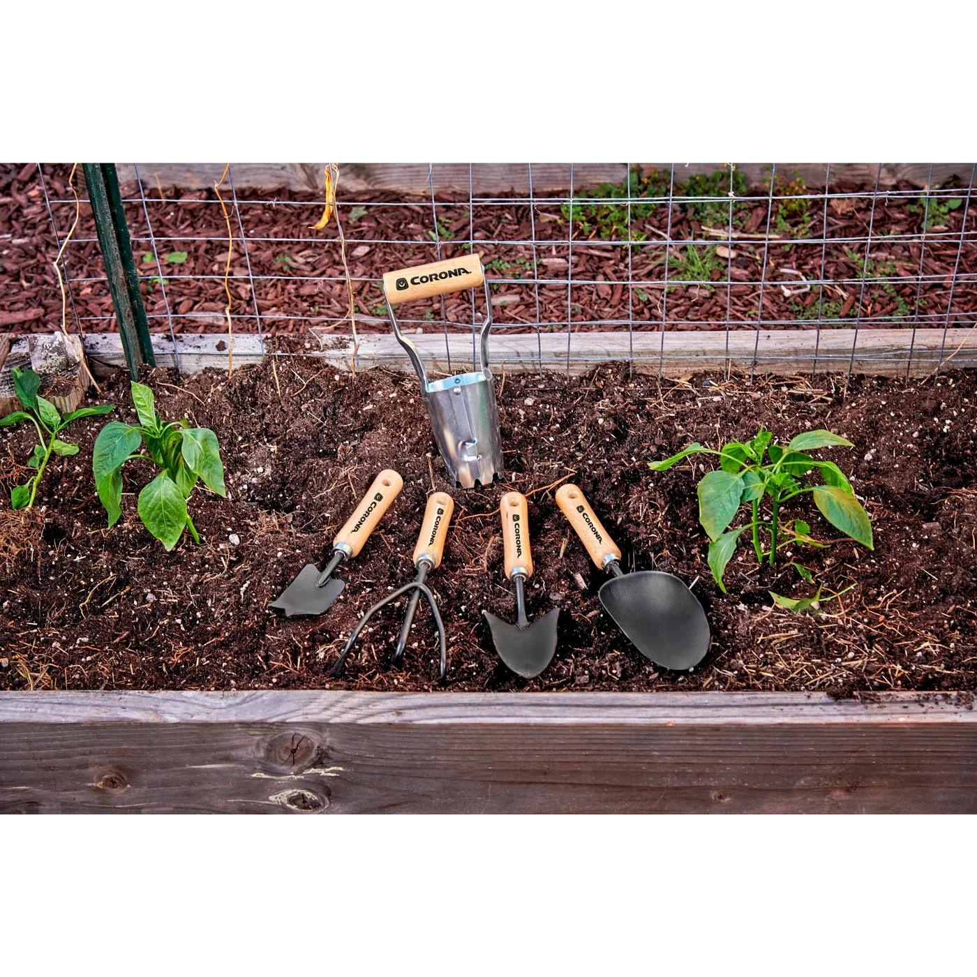 SP10002 short wood-handle tools in a planting bed; the long-handled tool and gloves are separate
