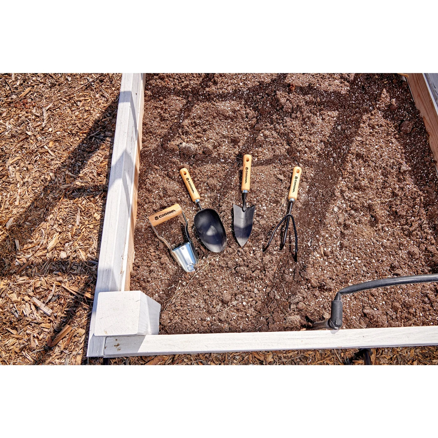 SP10002 three short wood-handle tools beside a raised bed; the large shovel is separate