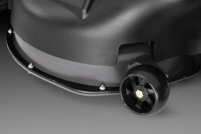 Close-up view of a lawn mower's cutting deck and wheel.